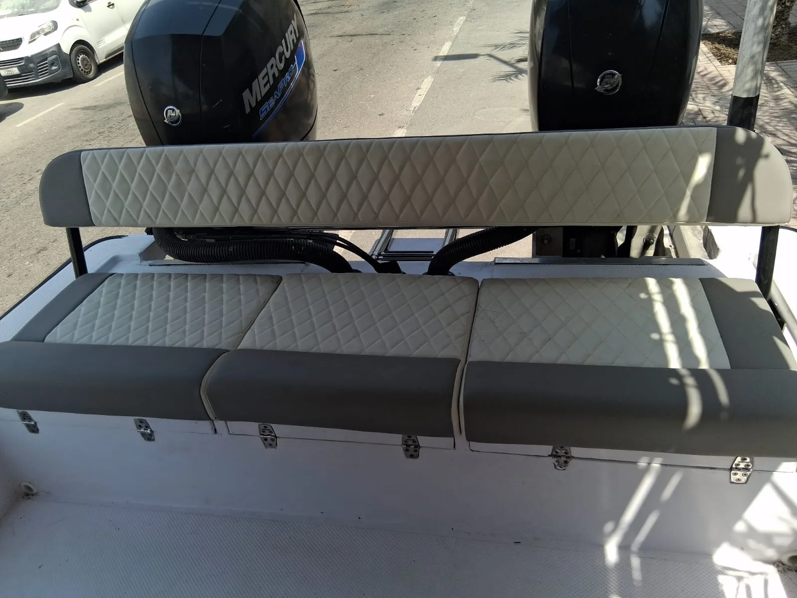 Diamond-stitched aft bench seating in front of twin Mercury SeaPro outboards