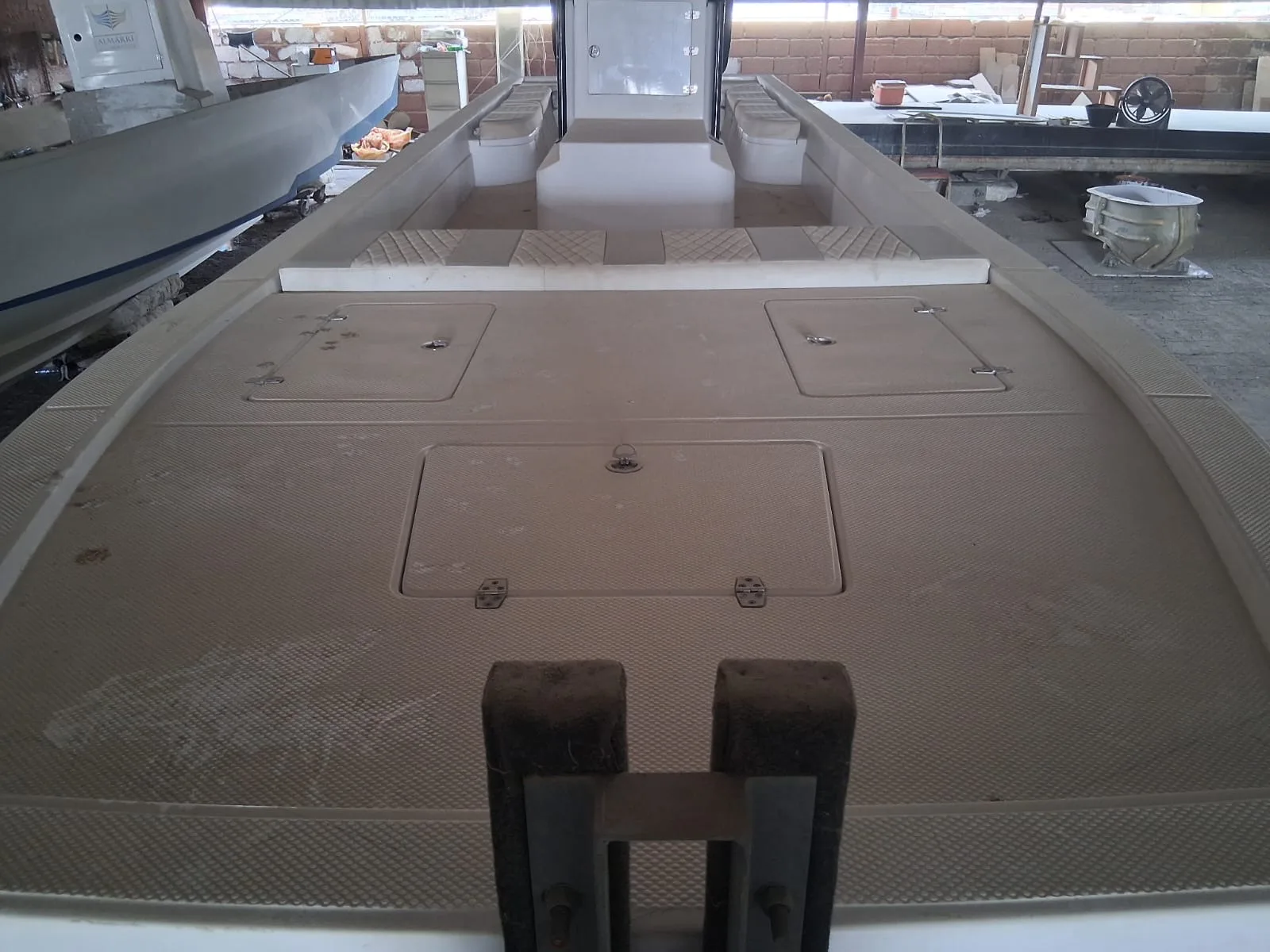 A wide bow deck with storage hatches, in build