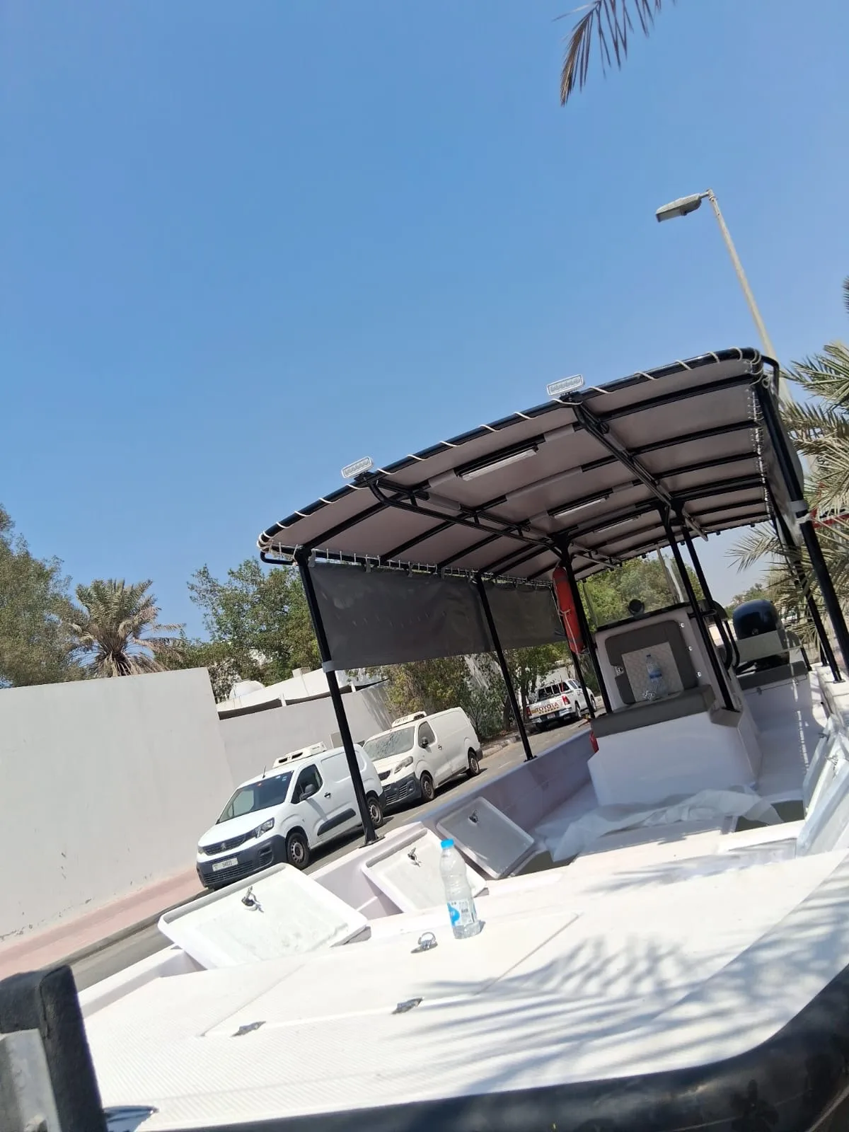 A finished white Almarri boat with full canopy on a trailer, ready for delivery