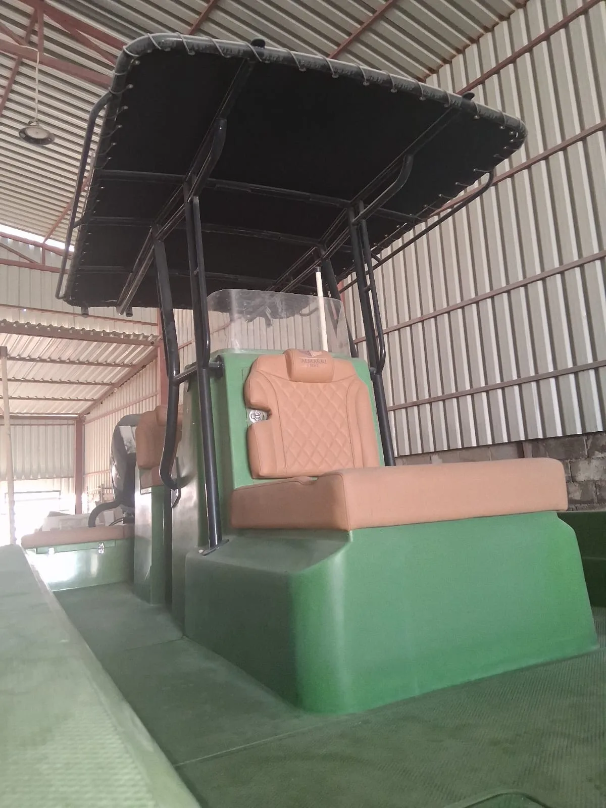 A green Almarri hull with tan diamond-stitched upholstery and black T-top, built to a customer's order