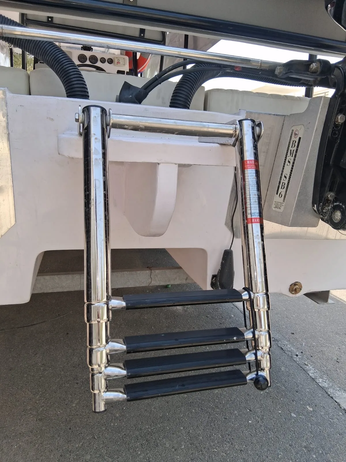 A polished stainless steel boarding ladder mounted on a boat transom