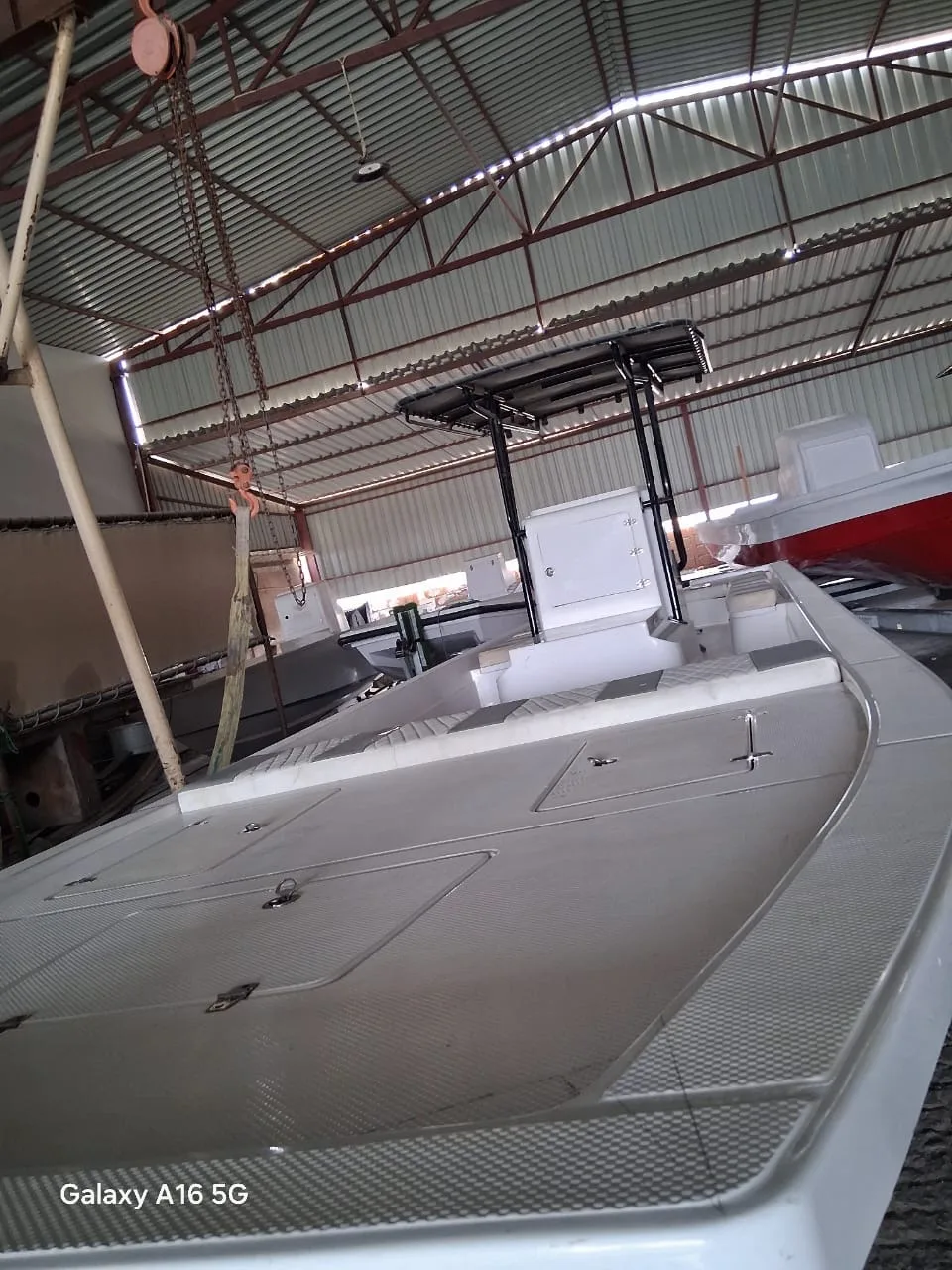 A center-console boat with black T-top frame in the workshop