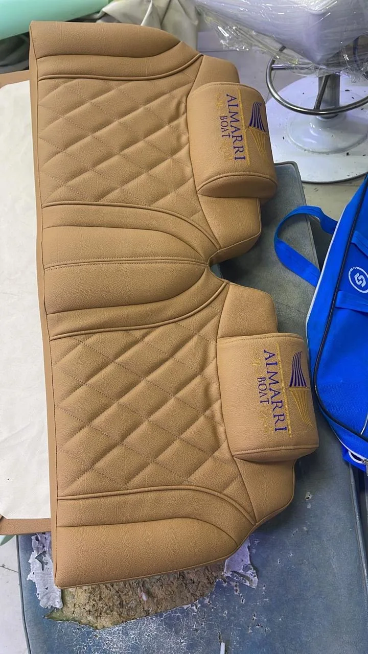 Tan diamond-stitched bench seats embroidered with the Almarri Boat name, fresh off the sewing table